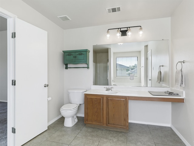 bathroom featuring toilet, vanity, and tile patterned flooring