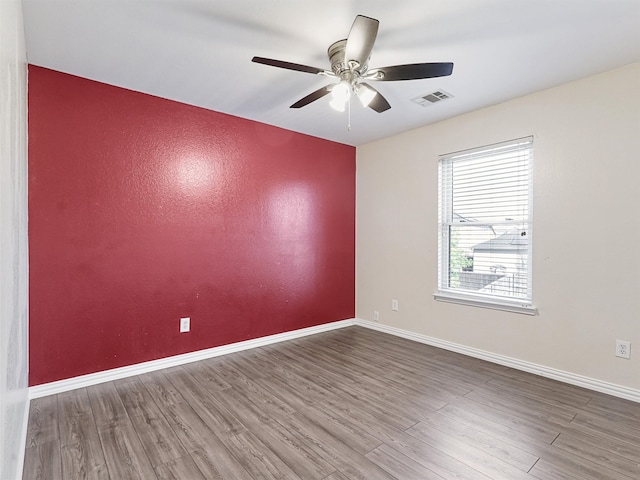 spare room with hardwood / wood-style flooring and ceiling fan