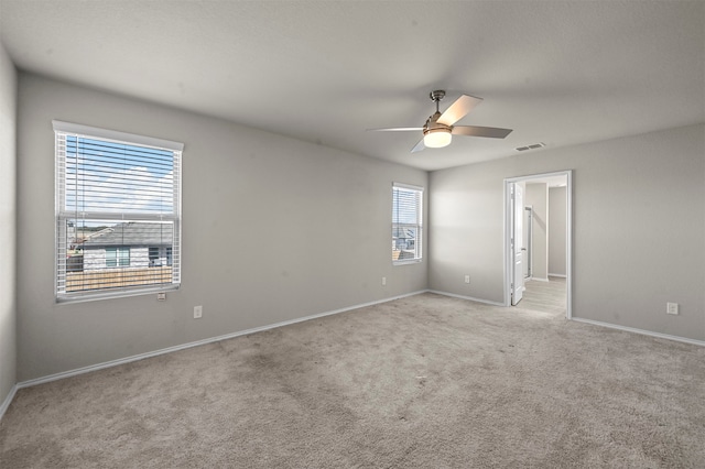 carpeted spare room with ceiling fan