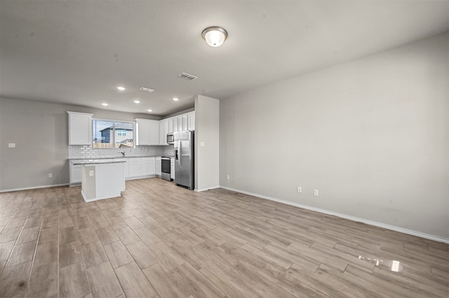 kitchen with light hardwood / wood-style flooring, white cabinetry, stainless steel appliances, and a kitchen island