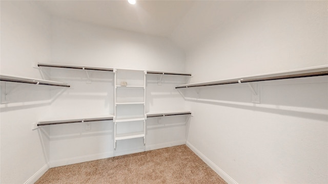 spacious closet featuring light colored carpet and vaulted ceiling