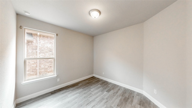 empty room featuring a healthy amount of sunlight and light hardwood / wood-style flooring