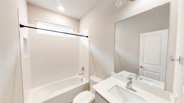 full bathroom featuring toilet, tiled shower / bath, and vanity