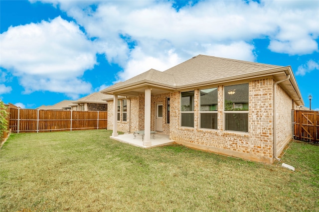 rear view of house with a patio area and a lawn