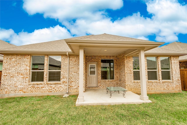 rear view of house featuring a patio and a lawn