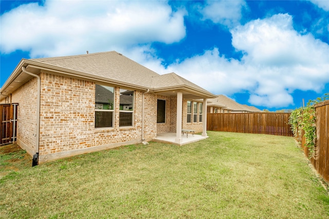 back of property with a patio and a lawn