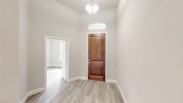 interior space with a towering ceiling and light wood-type flooring