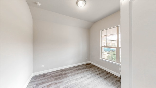 unfurnished room featuring vaulted ceiling and light hardwood / wood-style flooring