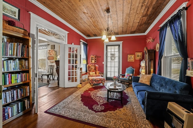 sitting room featuring wooden ceiling, a notable chandelier, heating unit, crown molding, and wood-type flooring