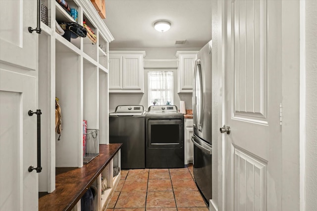 laundry room with cabinets, separate washer and dryer, and light tile patterned floors