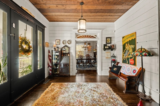 foyer entrance with wood walls, french doors, wooden ceiling, and dark hardwood / wood-style floors