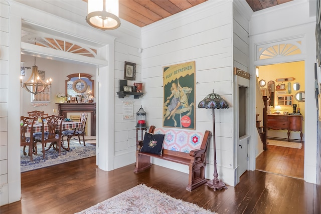 hall with dark hardwood / wood-style flooring, wooden ceiling, and an inviting chandelier