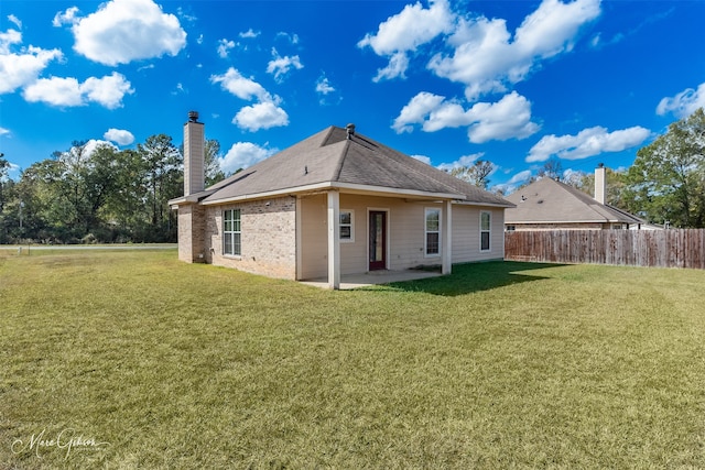 rear view of property with a patio area and a lawn