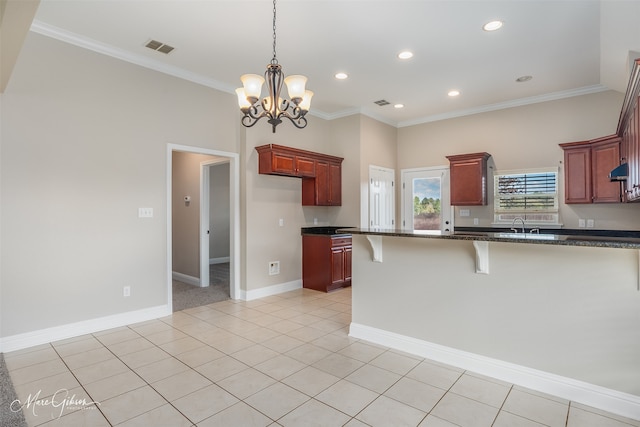 kitchen featuring light tile patterned flooring, pendant lighting, dark stone countertops, crown molding, and an inviting chandelier