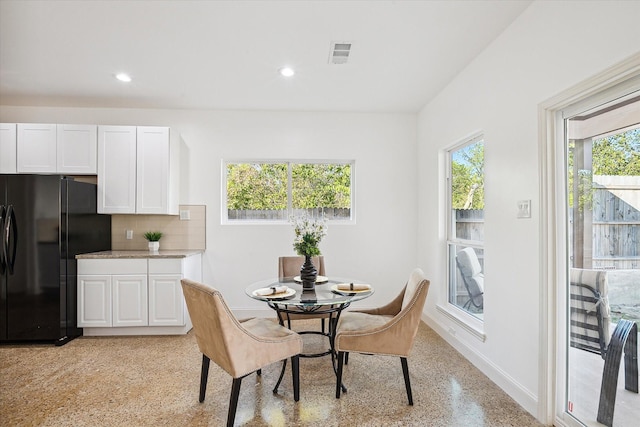 dining space featuring dark aggregate flooring, baseboards, and recessed lighting
