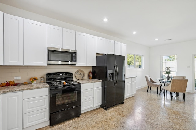 kitchen featuring light stone countertops, tasteful backsplash, black appliances, and white cabinets