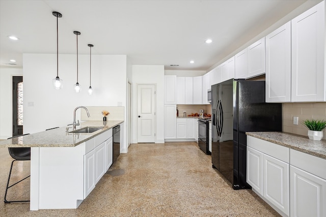 kitchen featuring white cabinets, light stone counters, black appliances, pendant lighting, and sink