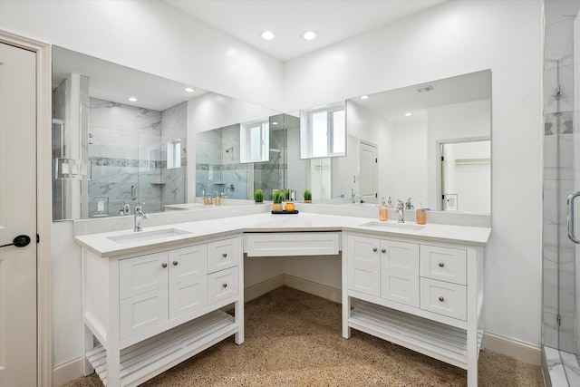 full bath featuring a marble finish shower, double vanity, recessed lighting, and baseboards