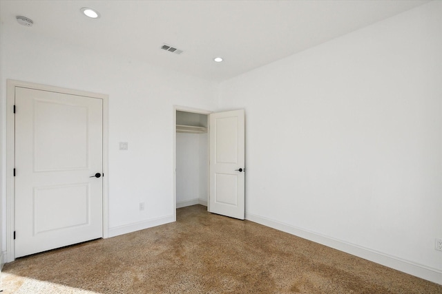 unfurnished bedroom featuring recessed lighting, baseboards, speckle patterned floor, and a closet
