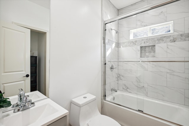 full bathroom with vanity, shower / bath combination with glass door, and toilet