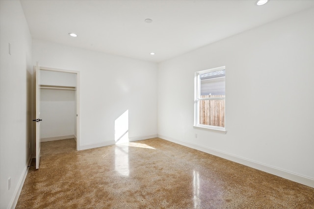 unfurnished bedroom featuring a spacious closet and a closet