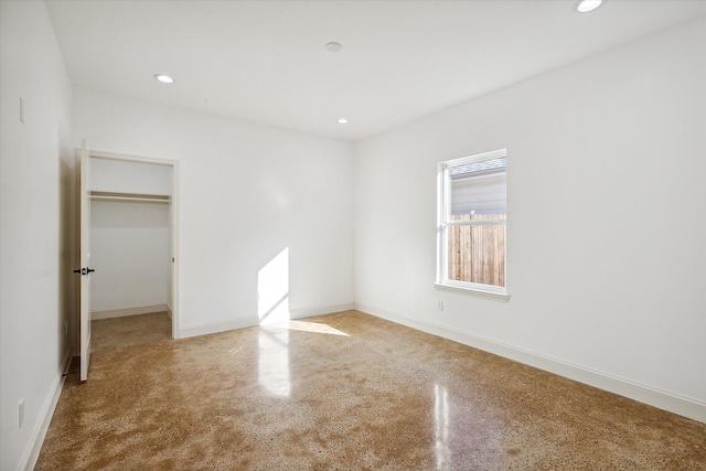 unfurnished bedroom with a spacious closet, recessed lighting, a closet, and baseboards