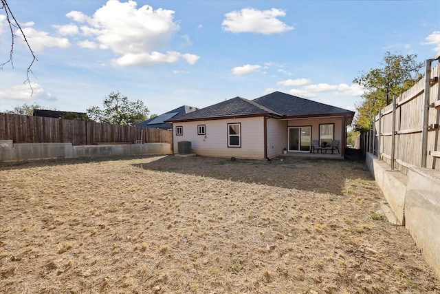 rear view of house featuring a fenced backyard, a patio, and a shingled roof