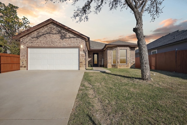 ranch-style home with a yard and a garage