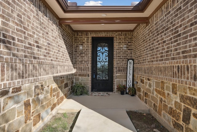 view of exterior entry featuring brick siding