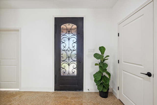 entryway featuring baseboards and speckle patterned floor