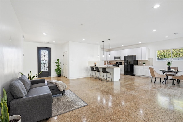 living area with recessed lighting, baseboards, and dark speckled floor