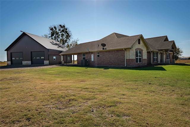 back of house with central AC, a garage, and a lawn