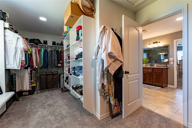 walk in closet with light colored carpet