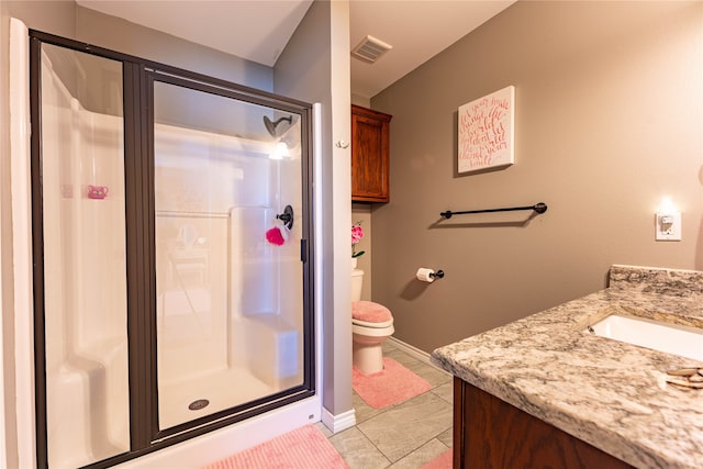 bathroom with toilet, walk in shower, vanity, and tile patterned flooring