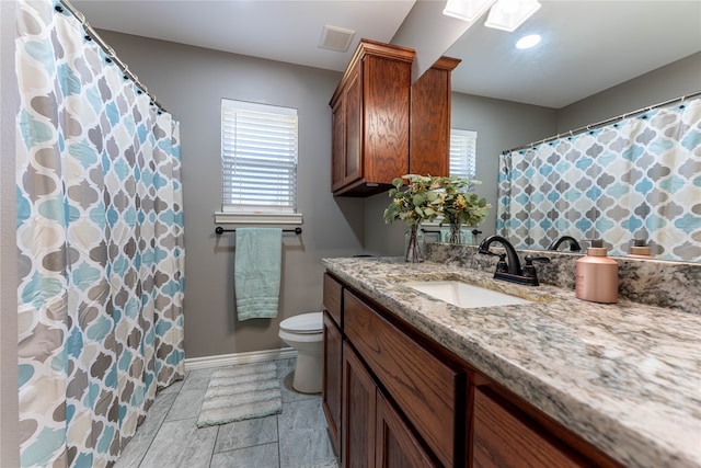 bathroom featuring vanity, a shower with shower curtain, toilet, and a skylight