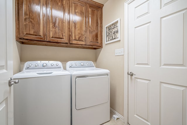 laundry room featuring cabinets and washer and clothes dryer