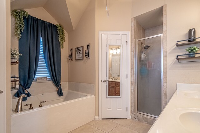 bathroom featuring tile patterned flooring, vanity, vaulted ceiling, and plus walk in shower