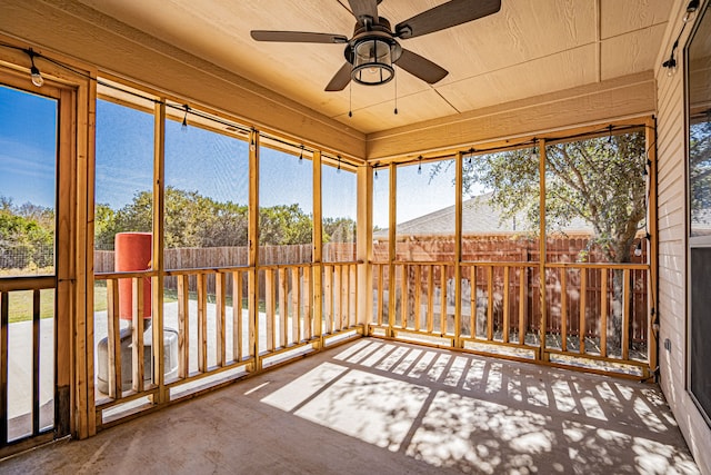 unfurnished sunroom with ceiling fan and plenty of natural light