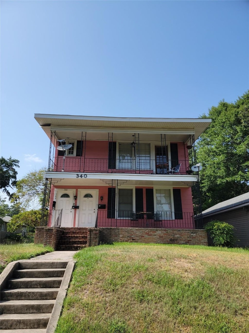 view of front of house with a balcony and a front lawn