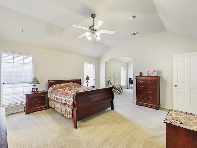 bedroom featuring vaulted ceiling, visible vents, arched walkways, and light carpet