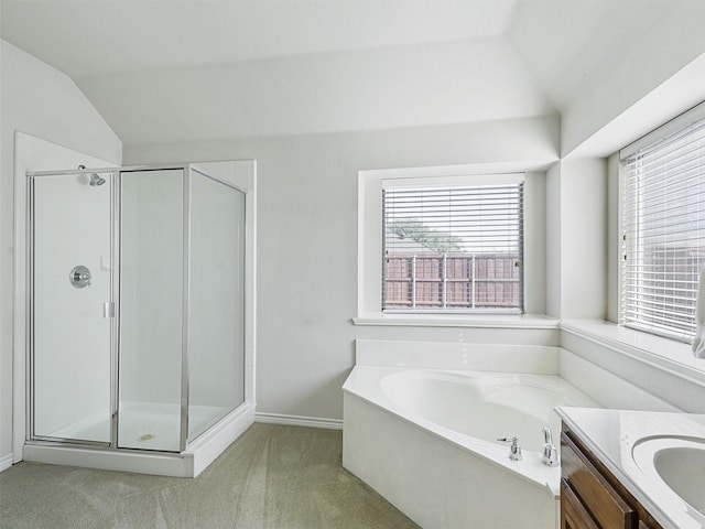 bathroom with a bath, a stall shower, and vaulted ceiling