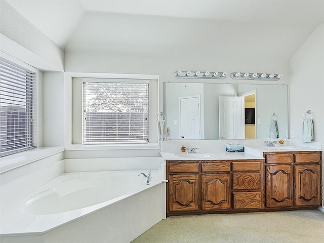 full bathroom featuring a sink, lofted ceiling, a bath, and double vanity