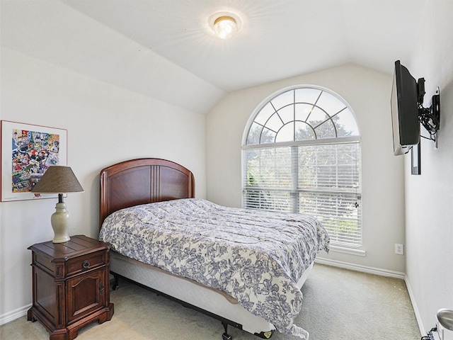 bedroom with light colored carpet, baseboards, and lofted ceiling