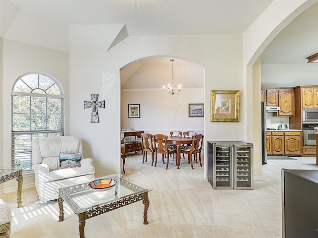 living room featuring an inviting chandelier, light colored carpet, and crown molding