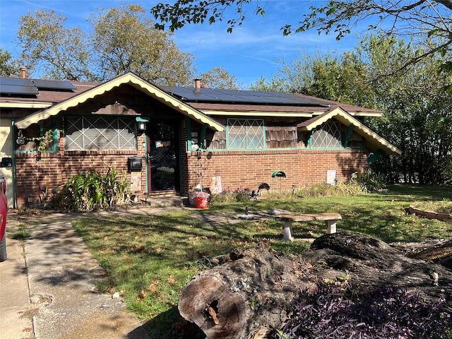 view of front of home with solar panels and a front lawn