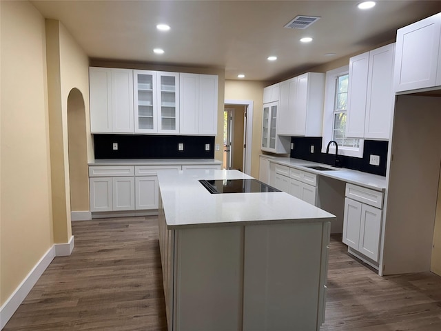 111 Pecan St, Terrell, TX 75160 - kitchen with recessed lighting, a sink, decorative backsplash, black electric cooktop, and a kitchen island