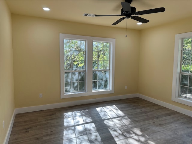 unfurnished room with ceiling fan, a healthy amount of sunlight, and dark hardwood / wood-style flooring