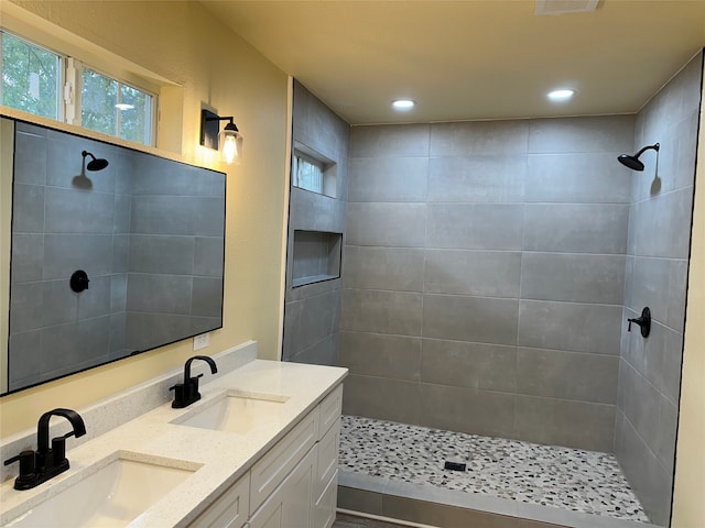 bathroom with vanity and a tile shower