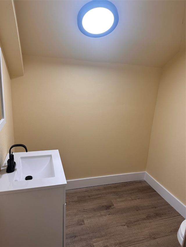 bathroom with hardwood / wood-style flooring, vanity, and toilet