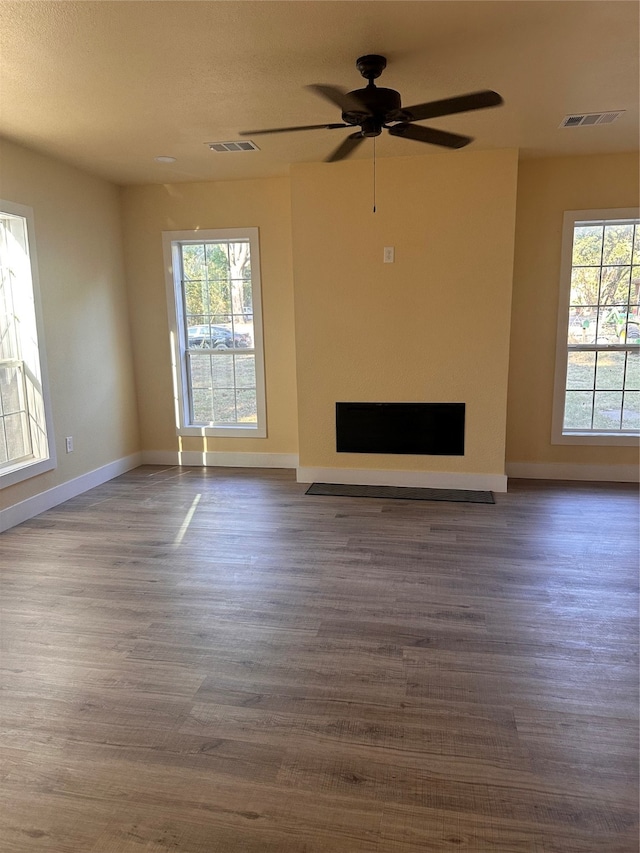 unfurnished living room with a textured ceiling, dark hardwood / wood-style floors, and ceiling fan